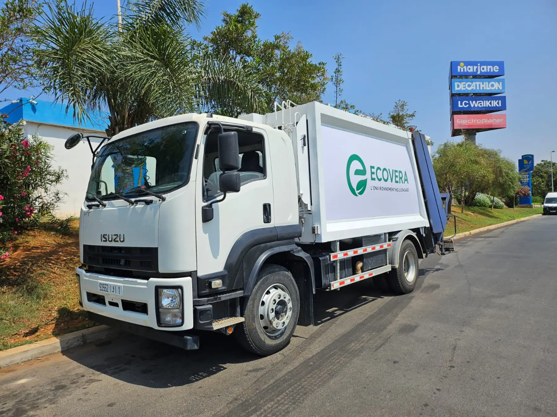 Camion-benne ECOVERA en tournée de collecte près d'une zone commerciale
