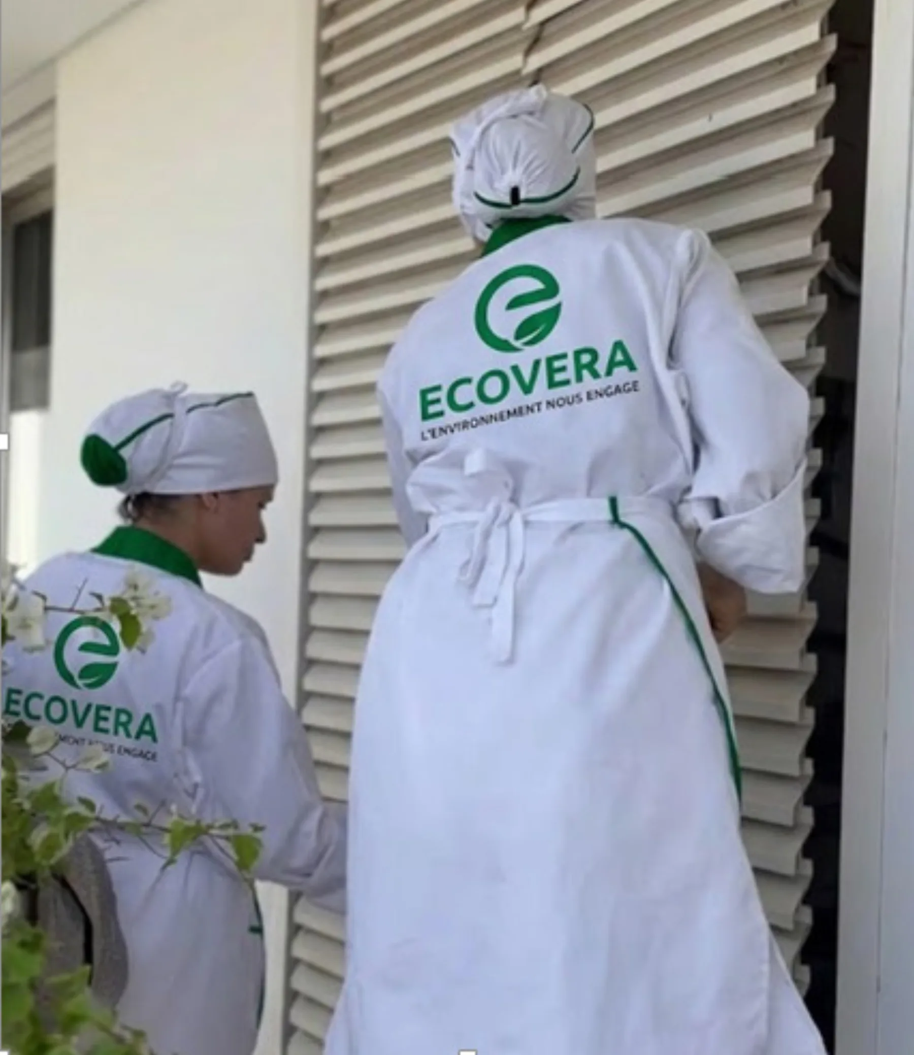 Agentes ECOVERA en tenue blanche d'hôtellerie devant une chambre à traiter